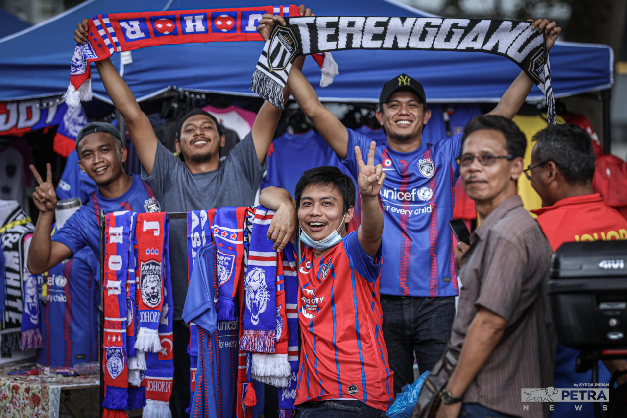 Vendors and fans show off team scarves available for purchase at Bukit Jalil national stadium. – SYEDA IMRAN/The Vibes pic, September 10, 2022