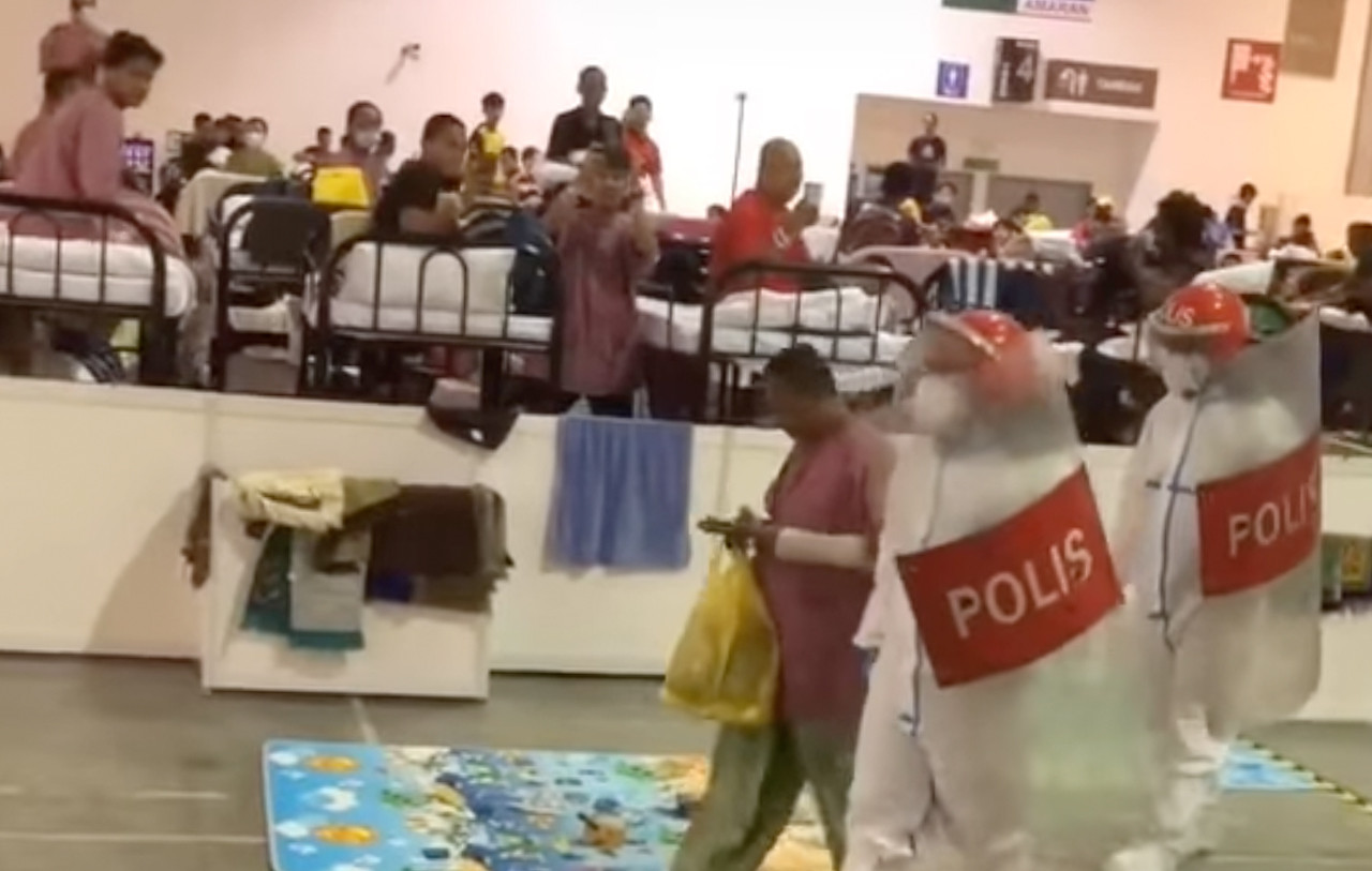 Another suspect being escorted by police at the MAEPS PKRC last night. – Screen grab, February 11, 2021