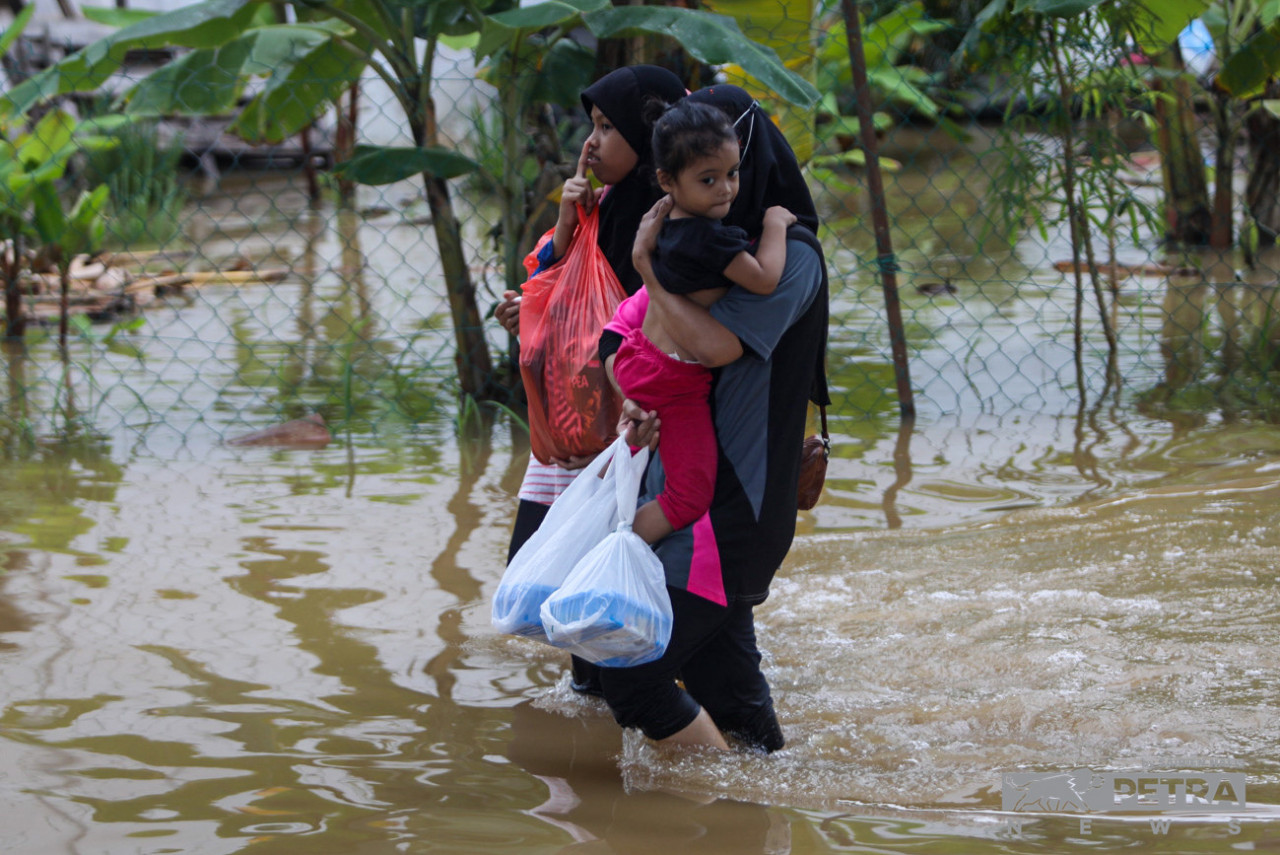A mother with her children walks through a flooded area near their home in Taman Sri Puteri, Klang. Caretaker prime minister Datuk Seri Ismail Sabri Yaakob chaired the Special Coordination Meeting of the Disaster Operations Control Centre virtually at 11.45pm last night to discuss on actions to be taken. – SAIRIEN NAFIS/The Vibes pic, November 11, 2022