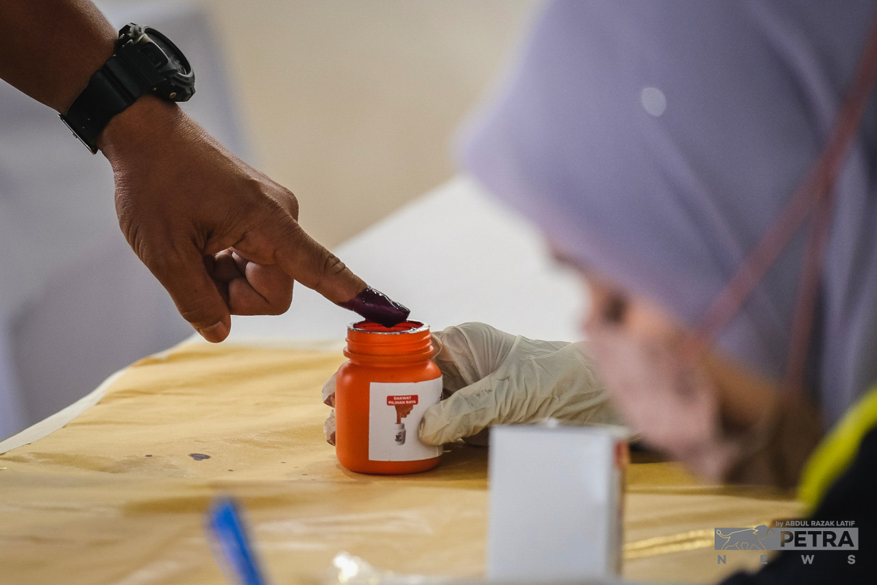 A voter dips their finger in indelible ink after casting their ballot to prove that they have conducted their responsibility as a rakyat at the Penang Contingent Police Headquarters today during the early voting session. – ABDUL RAZAK LATIF/The Vibes pic, November 15, 2022