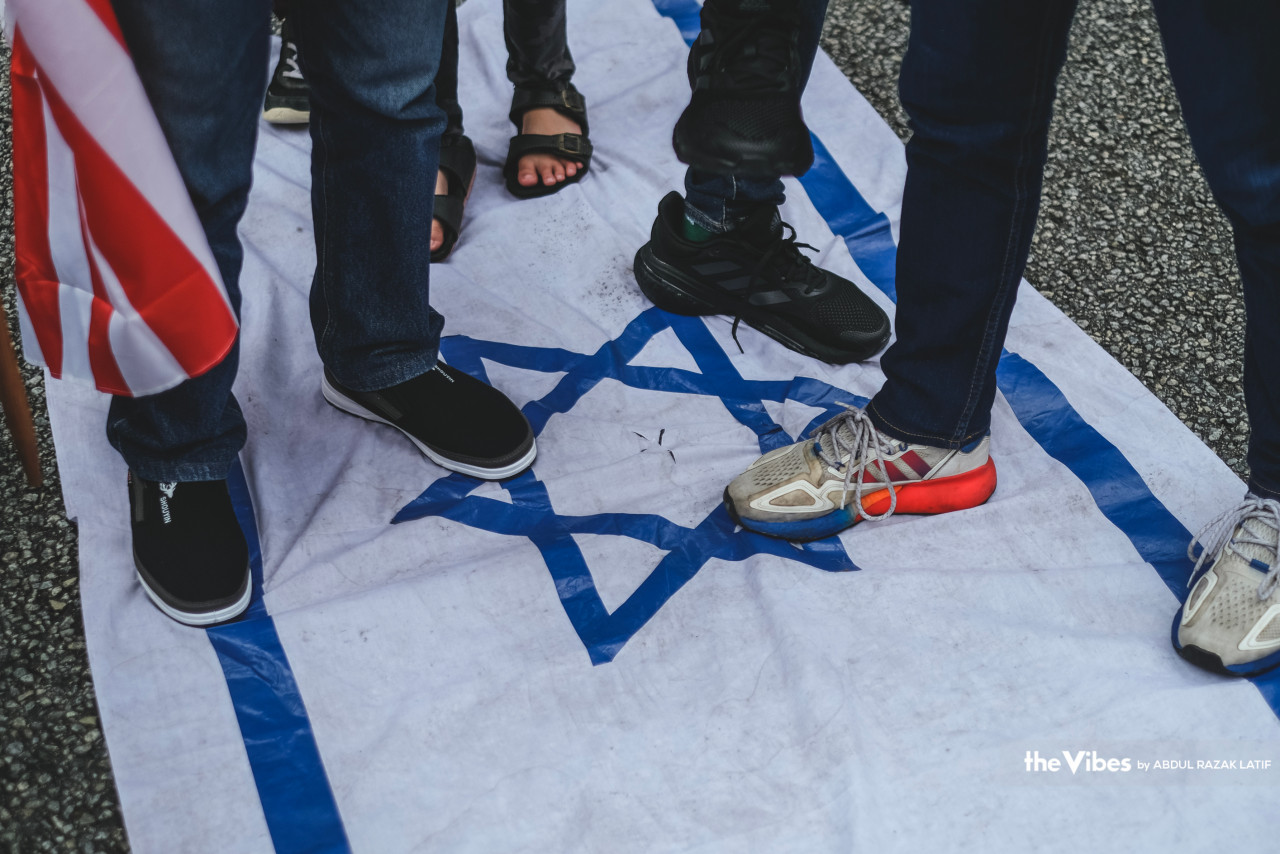 A group of protestors express their feelings towards Israel at the demonstration by tarnishing the Israeli flag. – ABDUL RAZAK LATIF/The Vibes pic, April 15, 2023