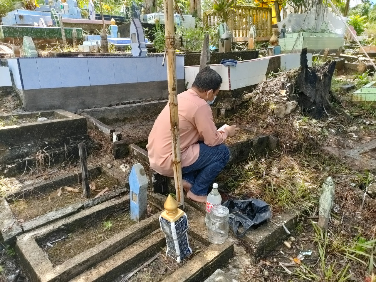 Sahlan Samsudin’s brother reciting the tahlil at their late father’s grave. – REBECCA CHONG/The Vibes pic, May 13, 2021