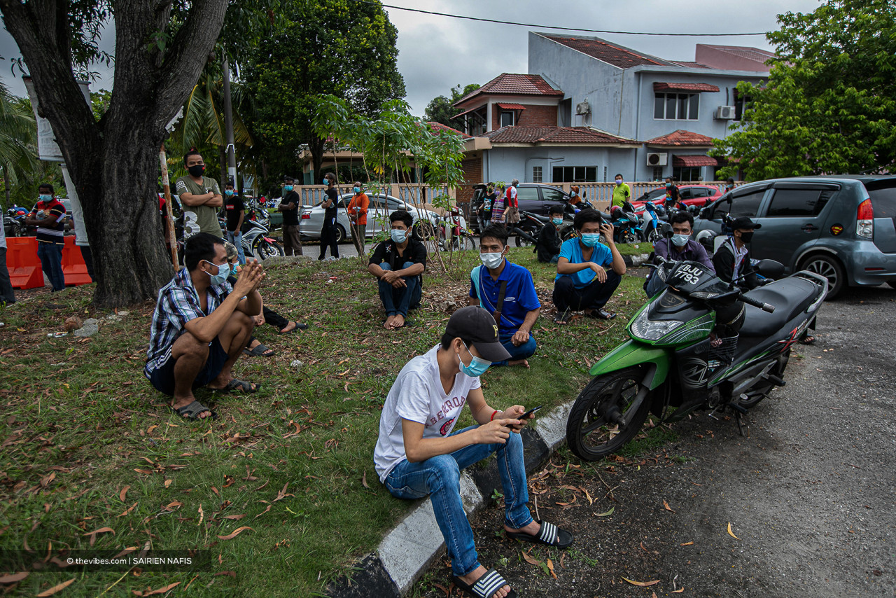 People sit by the roadside, visibly tired after waiting under the scorching sun since 9am this morning. – SAIRIEN NAFIS/The Vibes pic, July 13, 2021