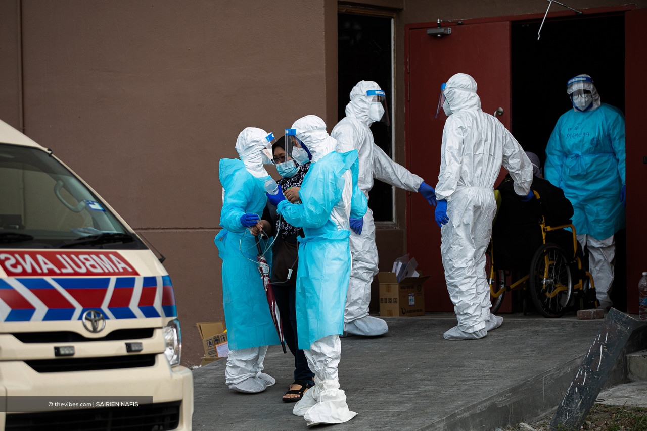 A woman being escorted to an ambulance by frontliners. – SAIRIEN NAFIS/The Vibes pic, July 13, 2021