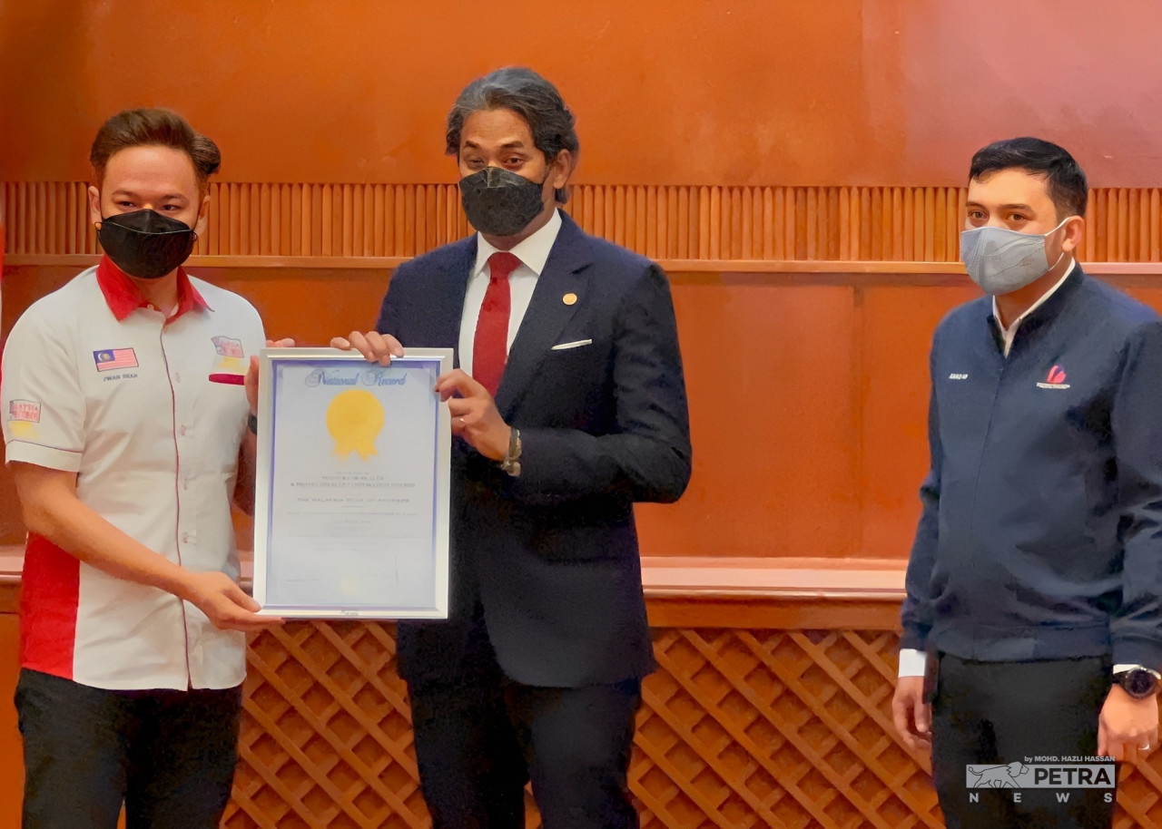 Health Minister Khairy Jamaluddin is presented with the Malaysia Book of Records’ certificate for the vaccination feat. – MOHD HAZLI HASSAN/The Vibes pic, September 14, 2022