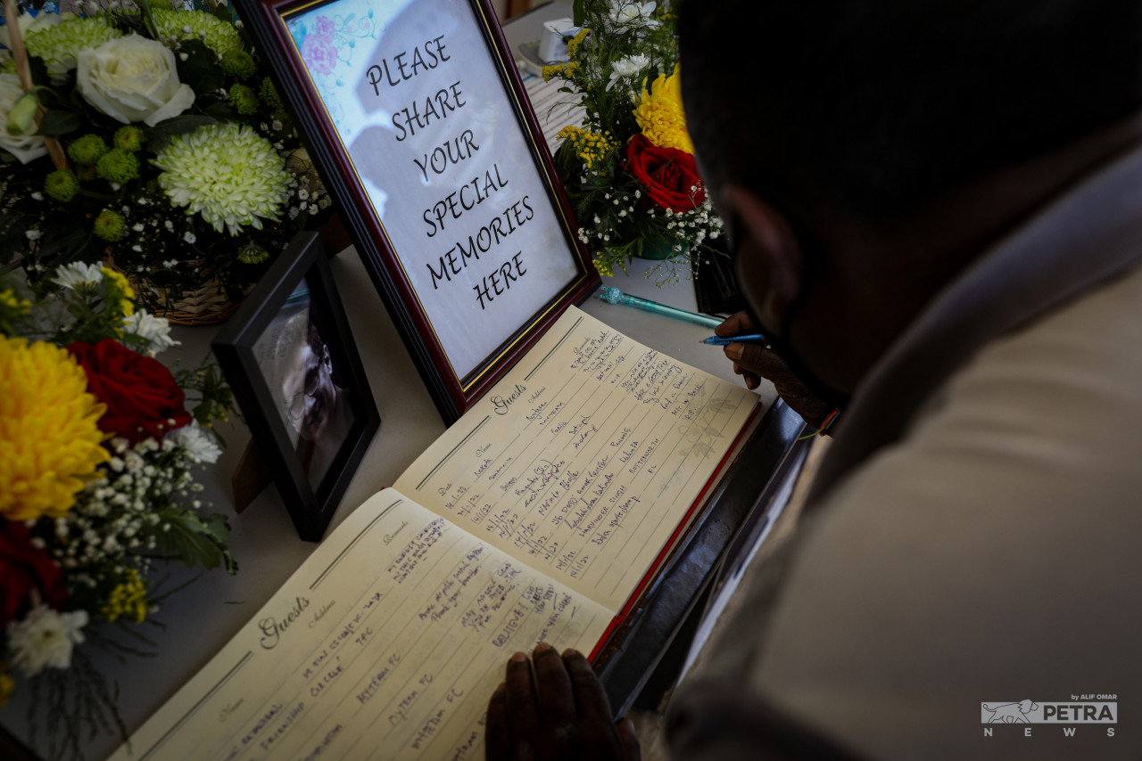 Guests pen down their condolences to the family of the deceased in the funeral guest book. – ALIF OMAR/The Vibes, January 14, 2022