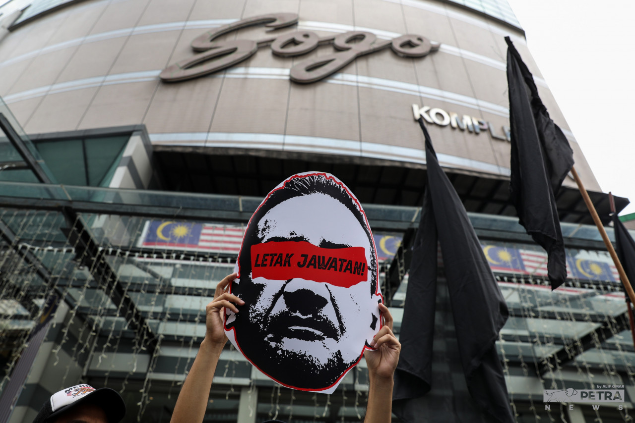 A protester carries a giant caricature of Datuk Seri Hishammuddin Hussein, with the words ‘Letak Jawatan’ (Resign) printed across. – ALIF OMAR/The Vibes pic, August 14, 2022