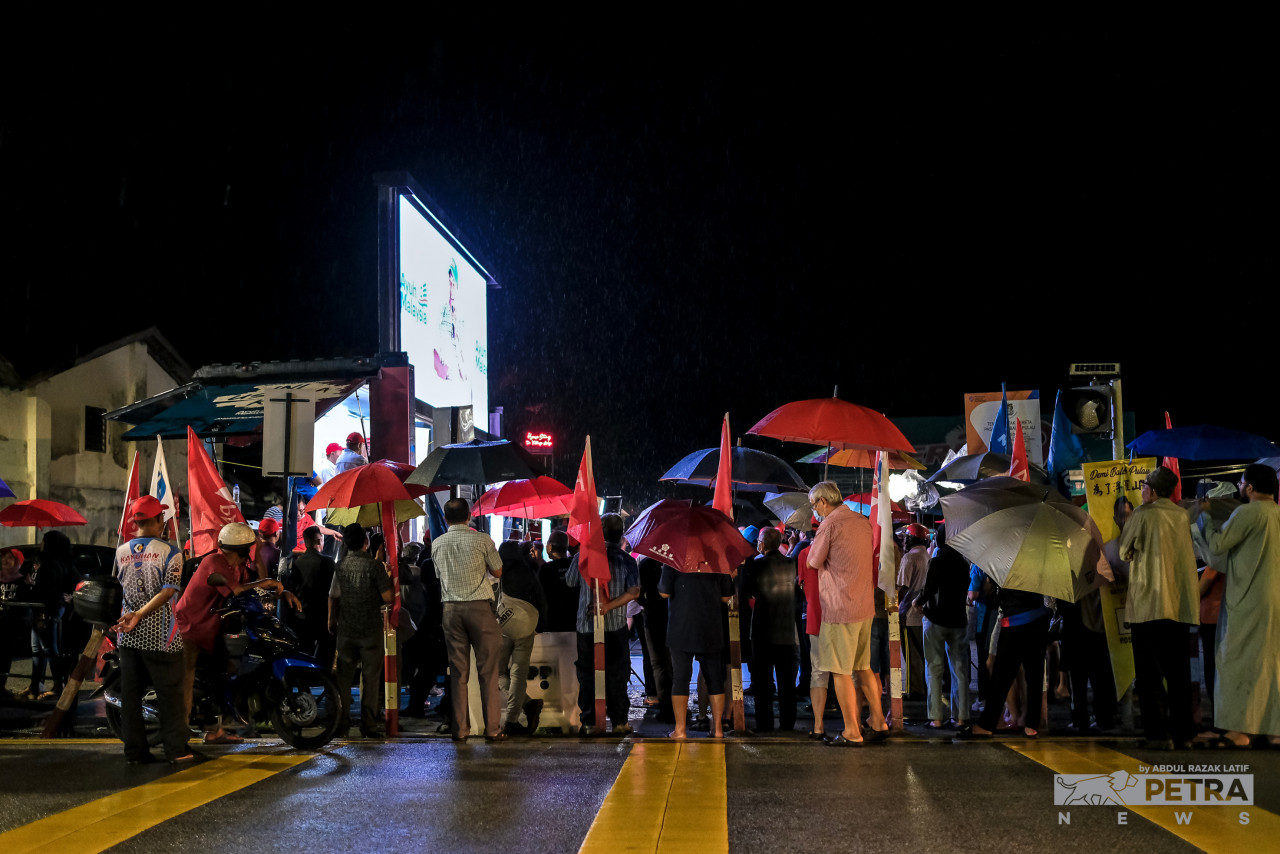 A crowd gathers in Balik Pulau last night, equipped with umbrellas and some with rain coats, to attend a ceramah programme by Pakatan Harapan despite the rainy weather. – ABDUL RAZAK LATIF/The Vibes pic, November 15, 2022
