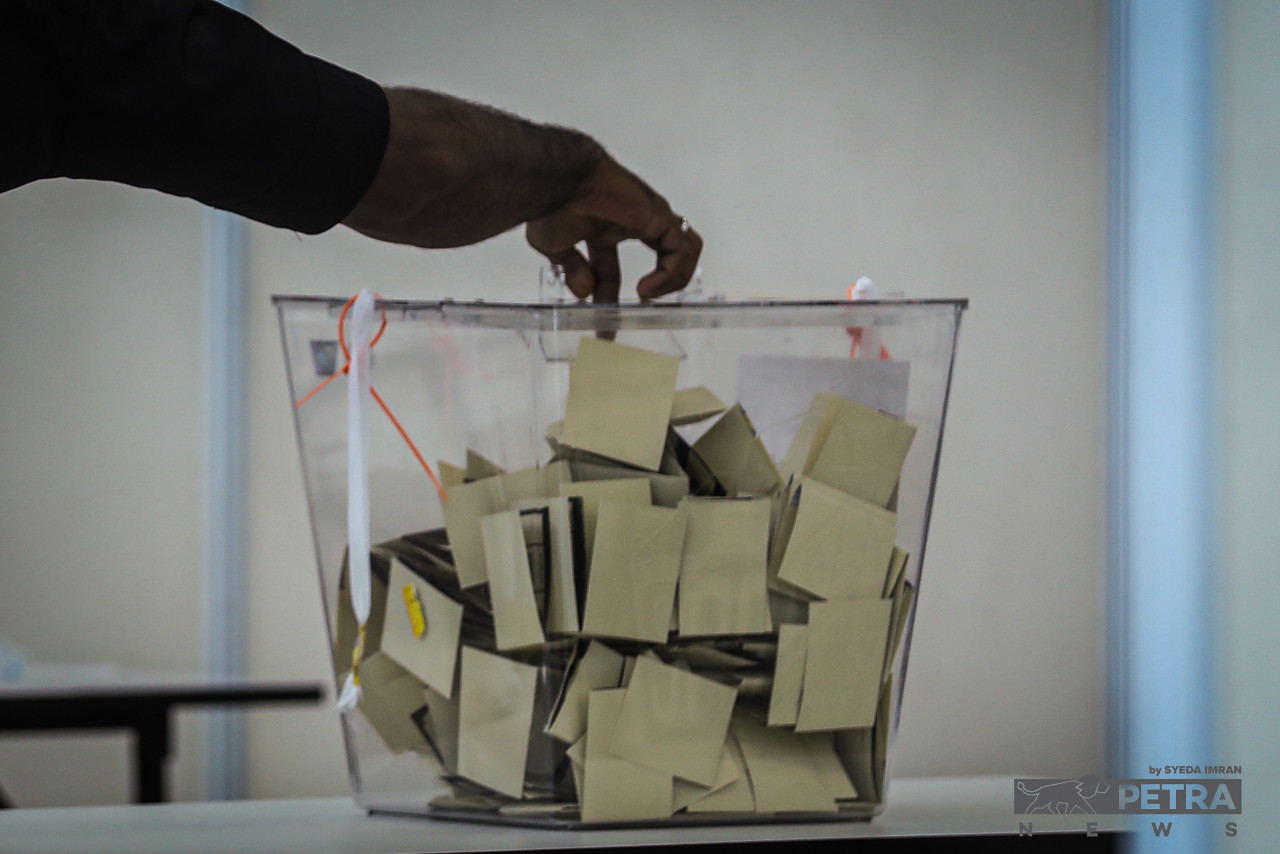 A voter puts his ballot in one of the ballot boxes provided at the Kuala Lumpur Contingent Police Headquarters in Jalan Hang Tuah today as early voting session for the 15th general election commences as early as 8am today for eligible voters. – SYEDA IMRAN/The Vibes pic, November 15, 2022