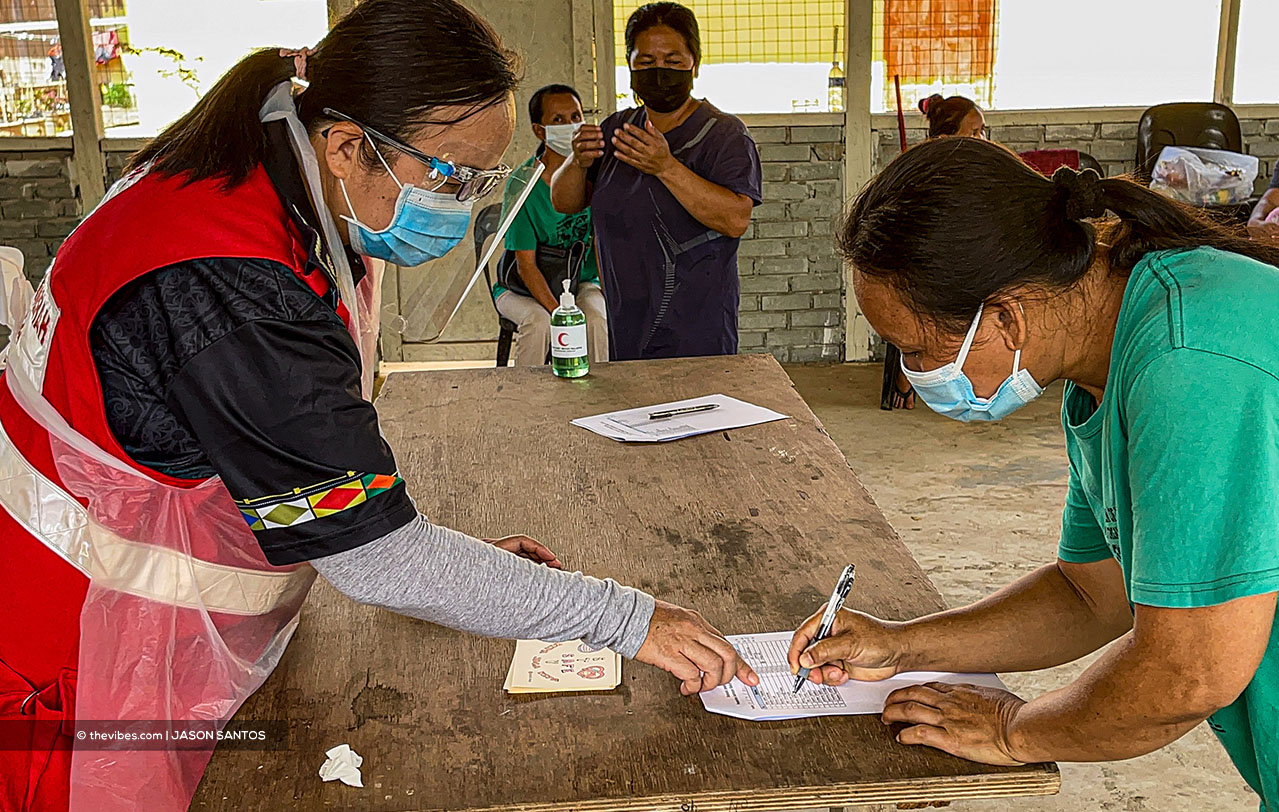 Malaysian Red Crescent Society Keningau chairman Marcella Vincent Lin (left) helping villagers register for their food in Sook, Keningau. – JASON SANTOS/The Vibes pic, July 17, 2021