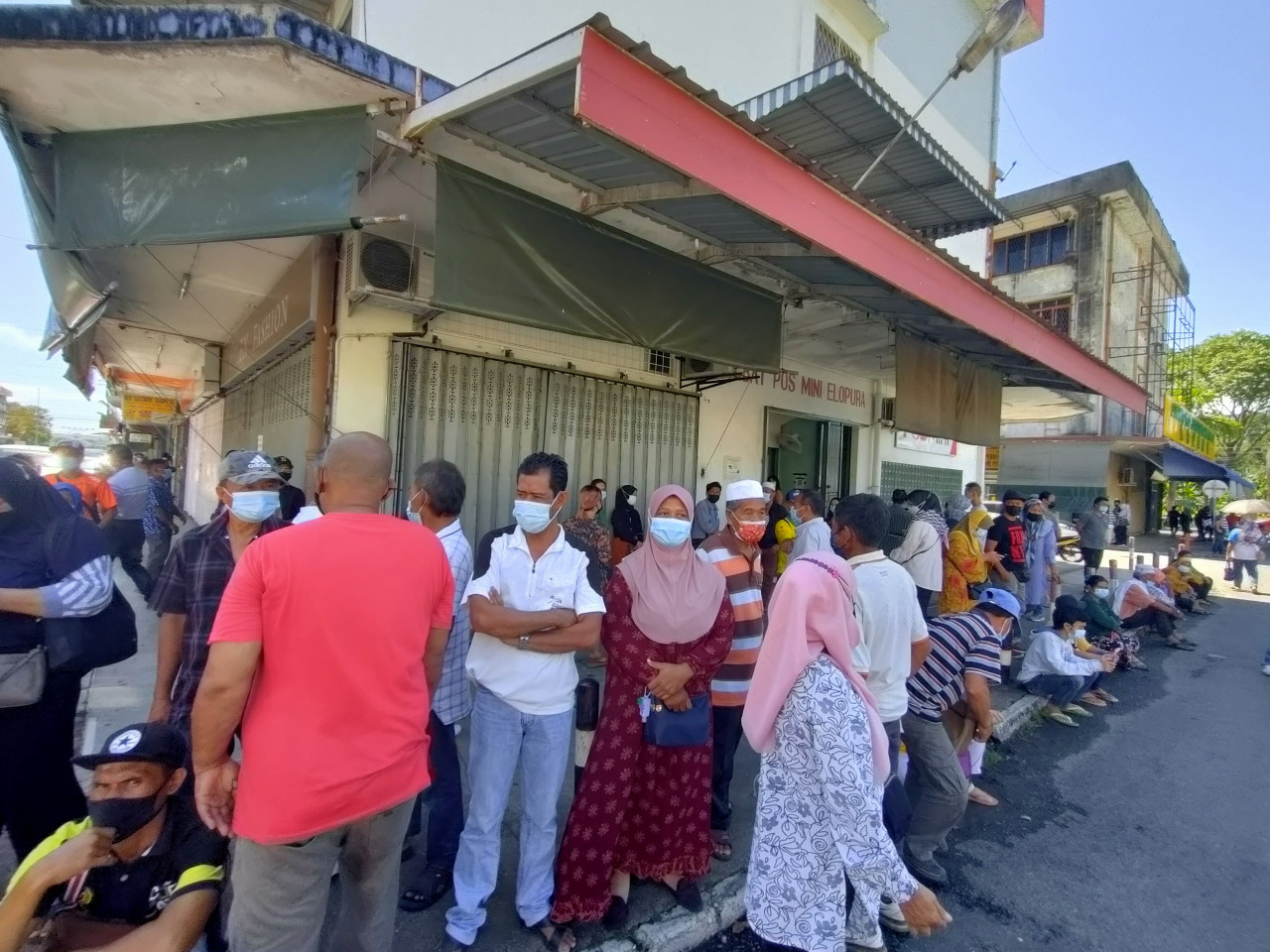 Over 100 people gathering to wait outside the Kim Fung shop lot near the vaccination centre, who have been there since 7am to avoid the sun. – REBECCA CHONG/The Vibes pic, August 16, 2021