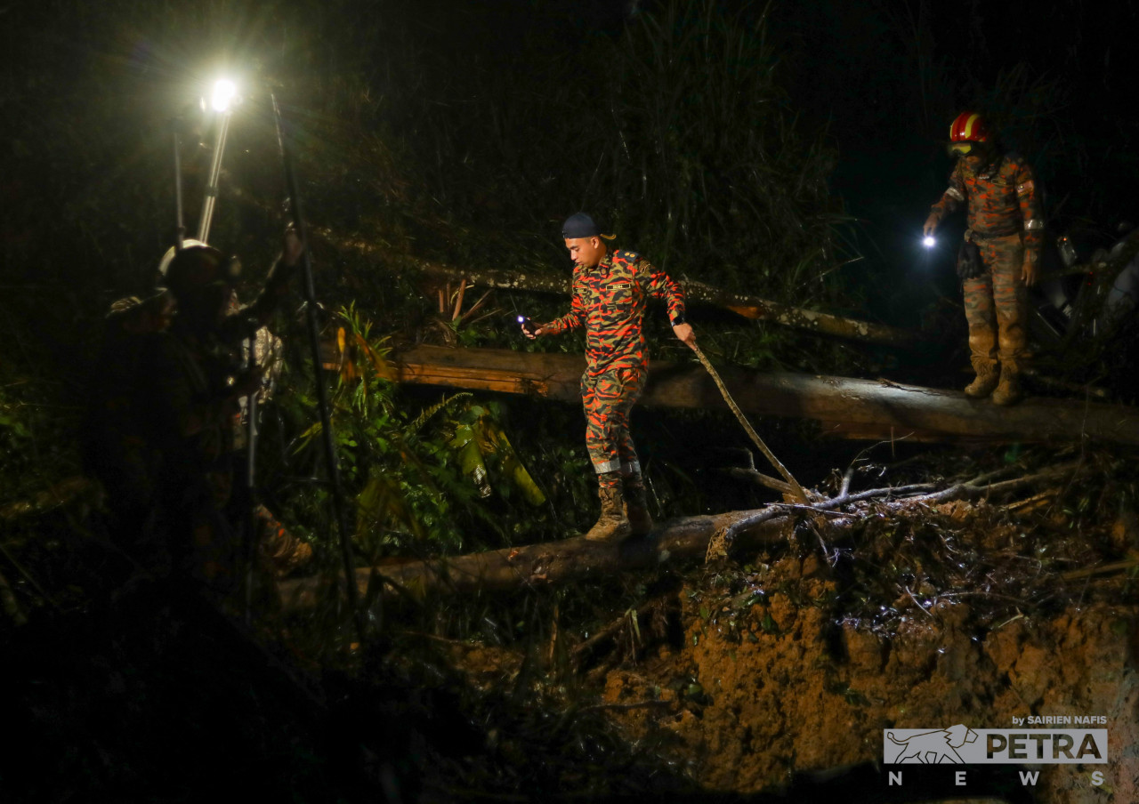 Rescuers tread through dangerous terrain, climbing fallen trees in the dark of the night after search-and-rescue operations resume at about 8pm last night. – SAIRIEN NAFIS/The Vibes pic, December 25, 2022