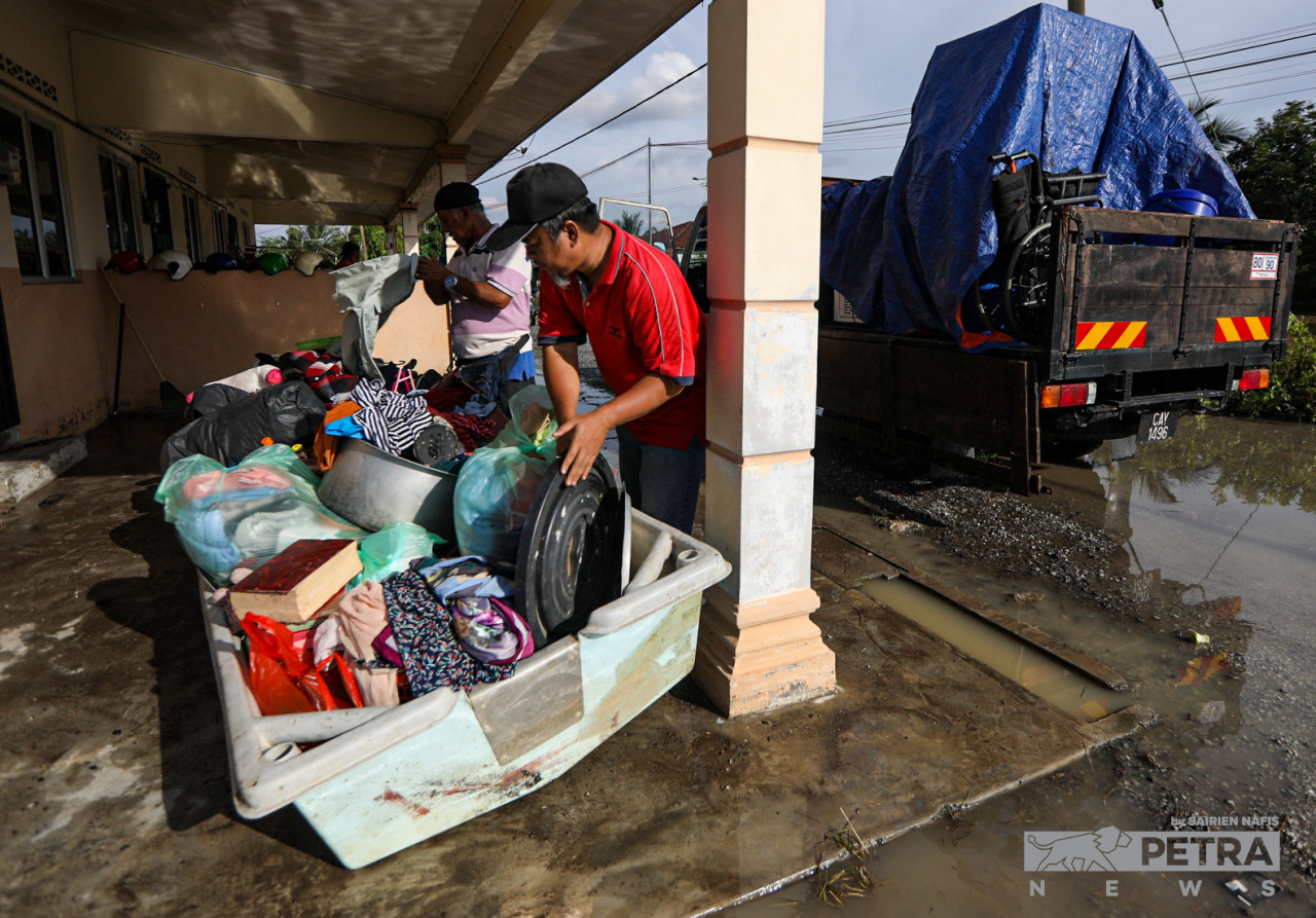 Ashraf Sleman (right), 44, moves family belongings to a safer place after his home flooded in Kg Chemperai, Dengkil, Selangor today. – SAIRIEN NAFIS/The Vibes pic, November 17, 2022