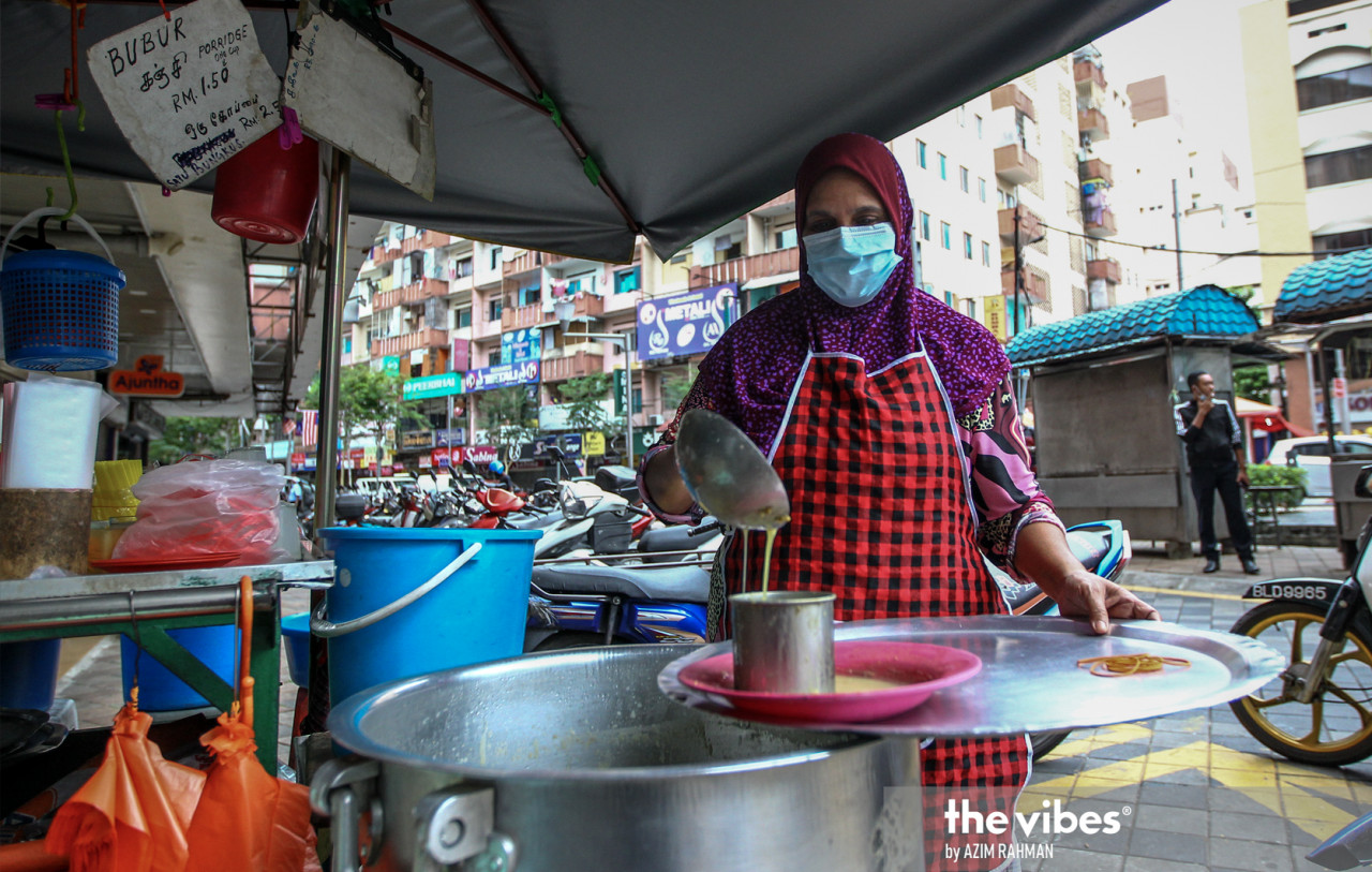 Roadside porridge and milk seller Fatimah Abdullah says she usually serves 500 to 600 customers a day before the movement restrictions were in place, but now finds it hard to get even 100. – AZIM RAHMAN/The Vibes pic, January 24, 2021