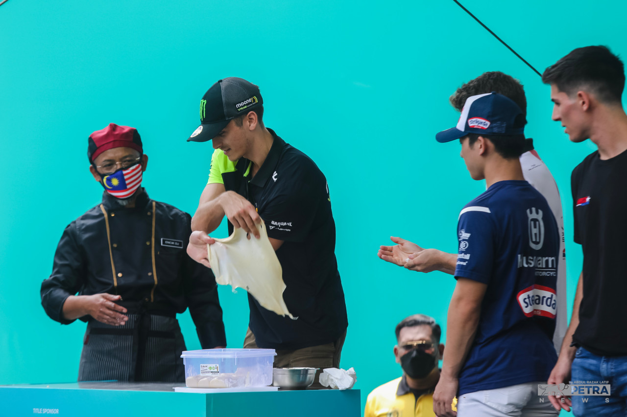 Riders watch on as one of them tries his hand at flipping a roti canai. – ABDUL RAZAK LATIF/The Vibes pic, October 19, 2022