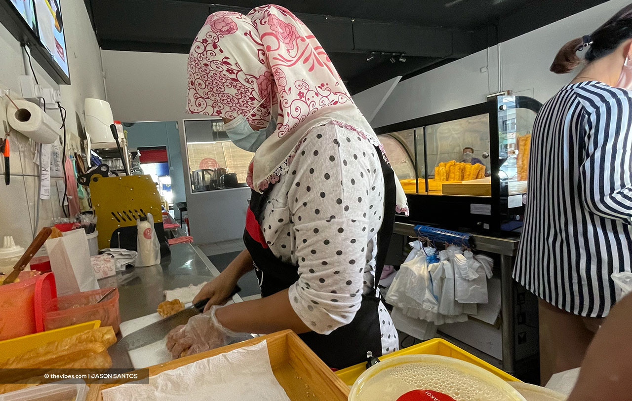 A woman cutting a pastry at a cafe in Kota Kinabalu. Much of the youth in Sabah are being squeezed out of jobs by more experienced workers, says SEA leader Yap Cheen Boon. – JASON SANTOS/The Vibes pic, April 7, 2021