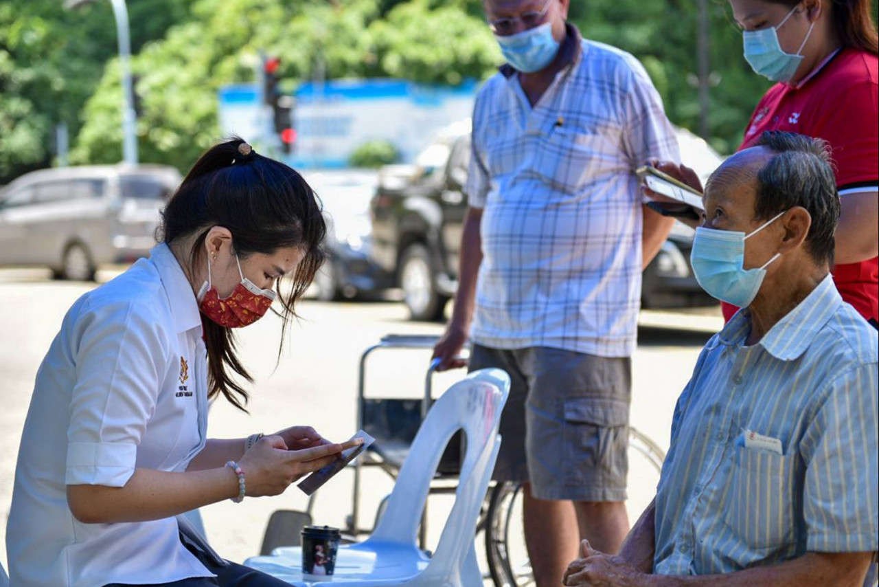 Sandakan MP Vivian Wong (left) speaking to an elderly Chinese man outside the community hall here. – File pic, May 17, 2021