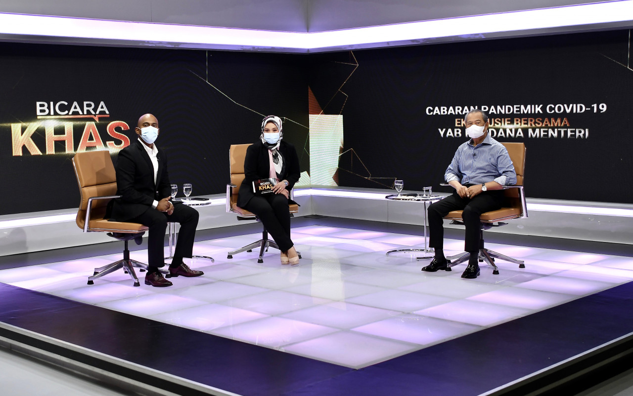 Prime Minister Tan Sri Muhyiddin Yassin (right) with Terrence Dass from RTM and Wan Syahrina Wan Ab Rahman from Bernama TV. He was speaking about the Covid-19 situation in the country in an exclusive interview. – Bernama pic, May 23, 2021