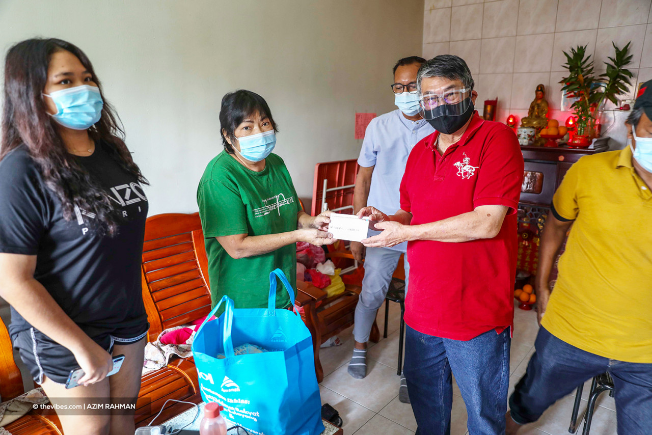 Selayang MP William Leong hands over aid to Kota Warisan PPR resident Yim Nyok Moi, who lost three family members, including her husband, to Covid-19. – AZIM RAHMAN/The Vibes pic, June 20, 2021