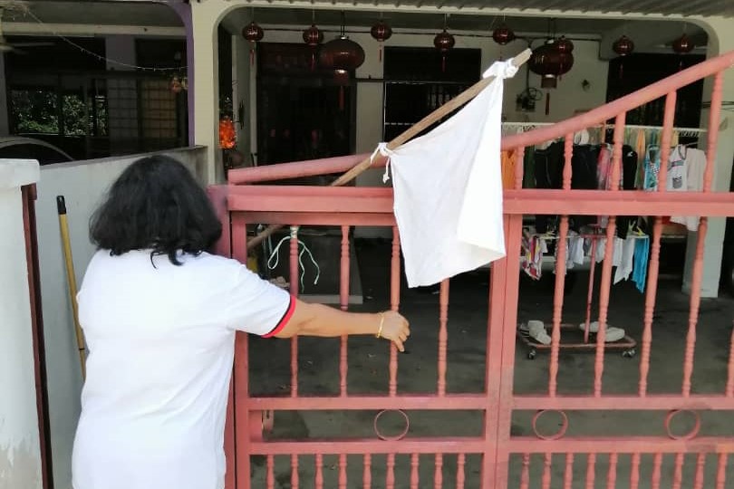 Social activist and retired teacher K. Puvaneswary visiting the home of a Chinese couple who put up a white flag seeking help in Kulim, Kedah. – File pic, July 5, 2021