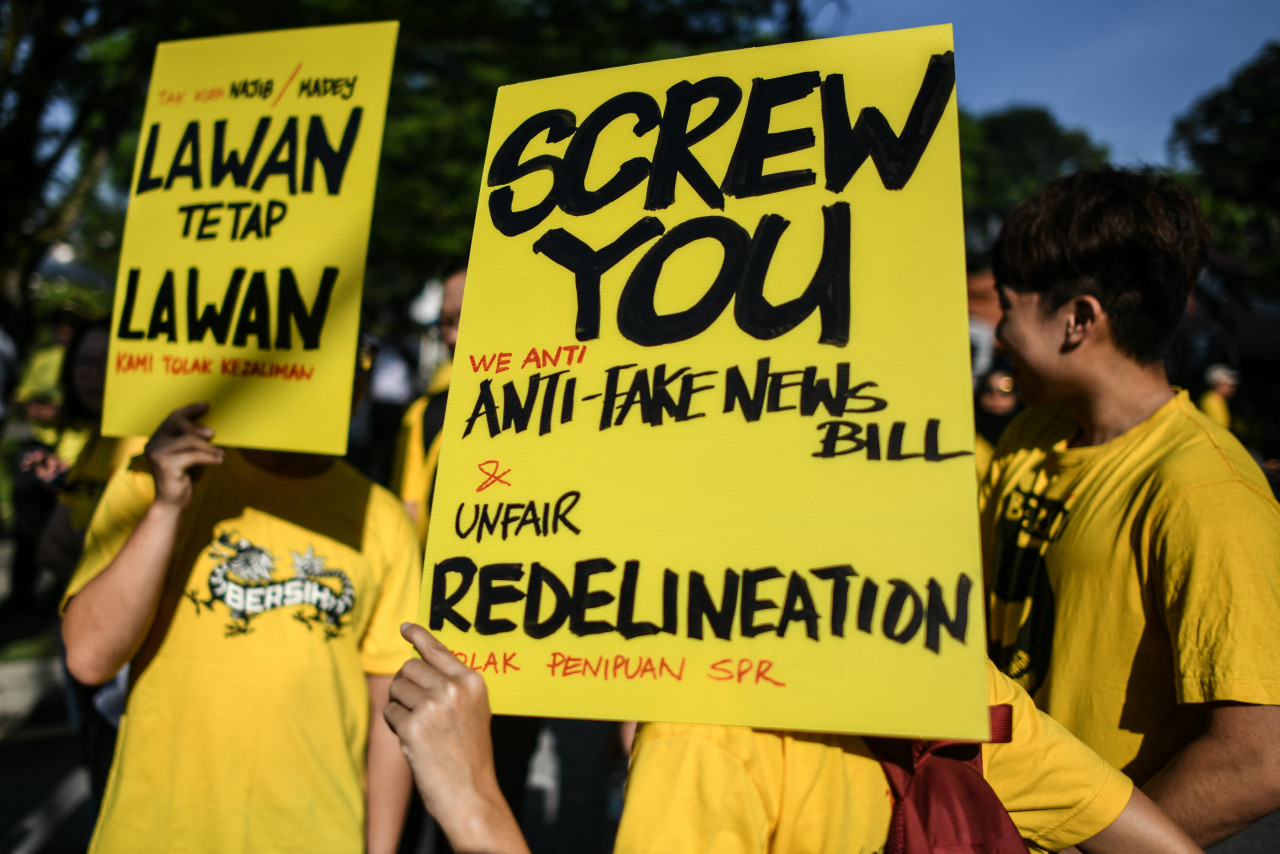 Protestors display placards during a Bersih 2.0 rally calling to stop a bill to redraw electoral boundaries near the Parliament building in Kuala Lumpur on March 28, 2018. – AFP pic, July 9, 2021