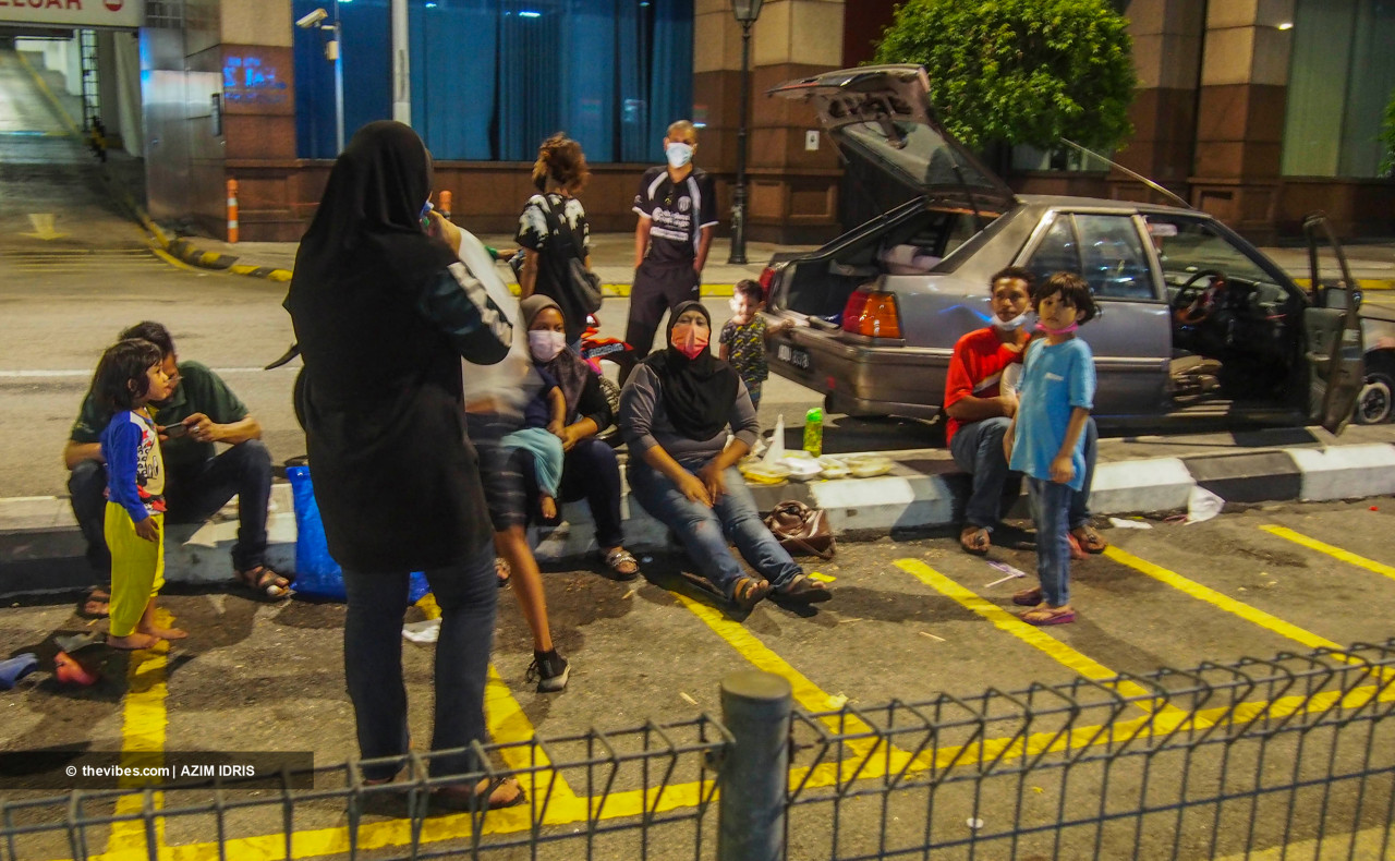 Zairul Azhar with his family and others waiting for aid from NGOs in Chow Kit last night. – A. AZIM RAHMAN/The Vibes pic, July 20, 2021