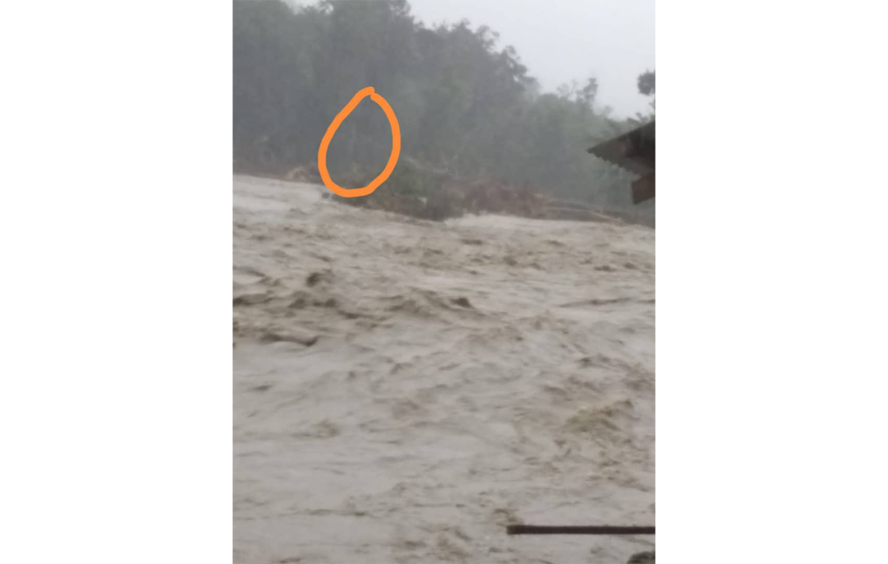 The circled area is where Leonard Lawrence and his dog were trapped after heavy rainfall in Ranau caused the river near his home to overflow. – Bomba pic, January 3, 2022