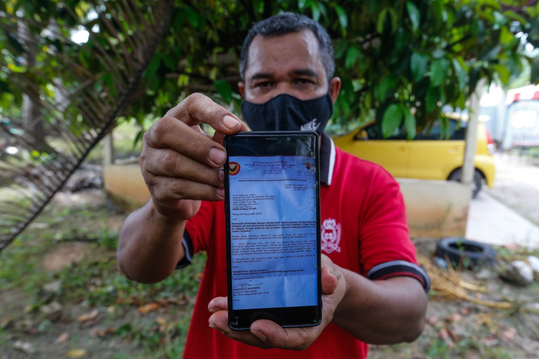 Saheme Hashim shows the official letter from former menteri besar Datuk Seri Mukhriz Mahathir promising to help the residents of Kg Baru Pulau Tiga get new homes. – SOFIA NASIR/The Vibes pic, January 3, 2022