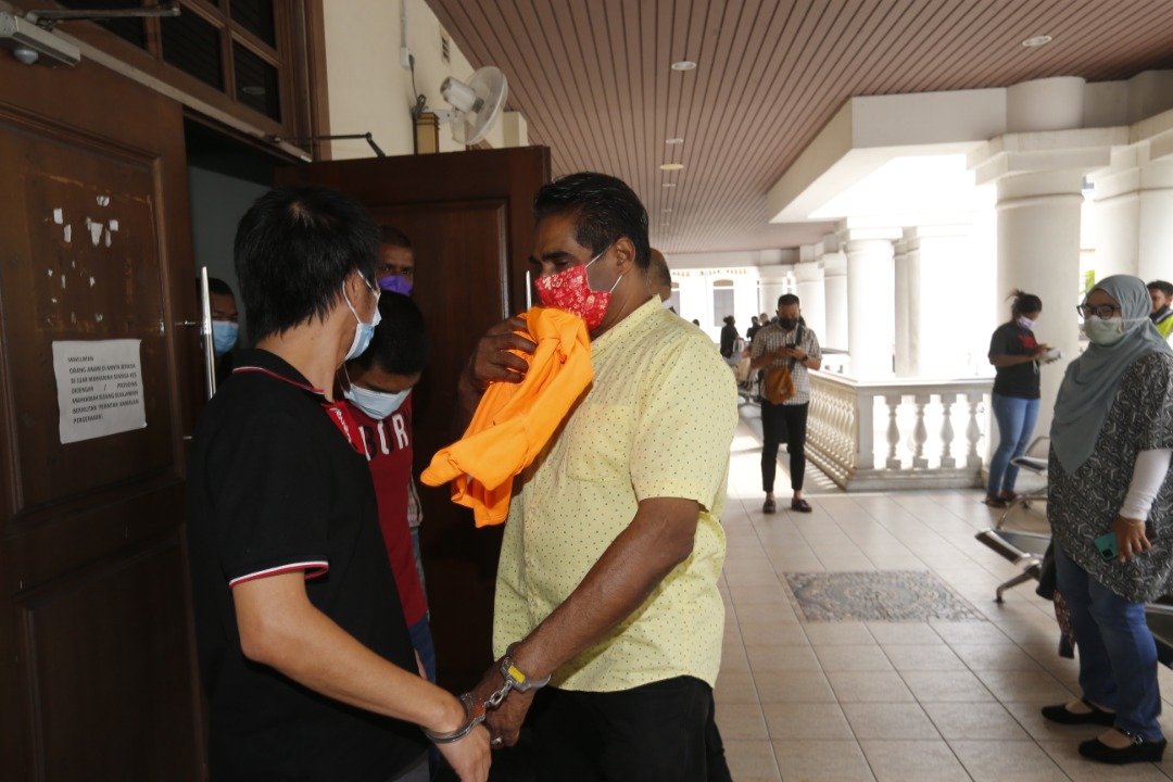 One of the accused, S. Muniandy (in yellow shirt) being escorted by police at the Penang magistrate’s court today. He is charged with conspiring to assist in the release of the suspects. – SOFIA NASIR/The Vibes pic, April 13, 2022