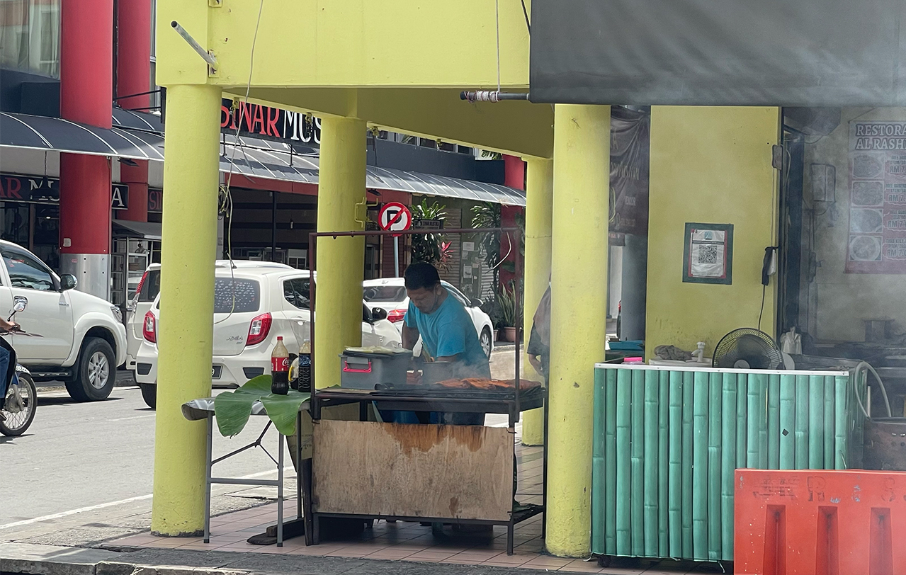 A stall operator selling grilled fish opens up his business in Putatan town. Poor and B40 families make up about 17% and 50% of the constituency’s 60,000 population, says a local stall operator. – JASON SANTOS/The Vibes pic, July 11, 2022 