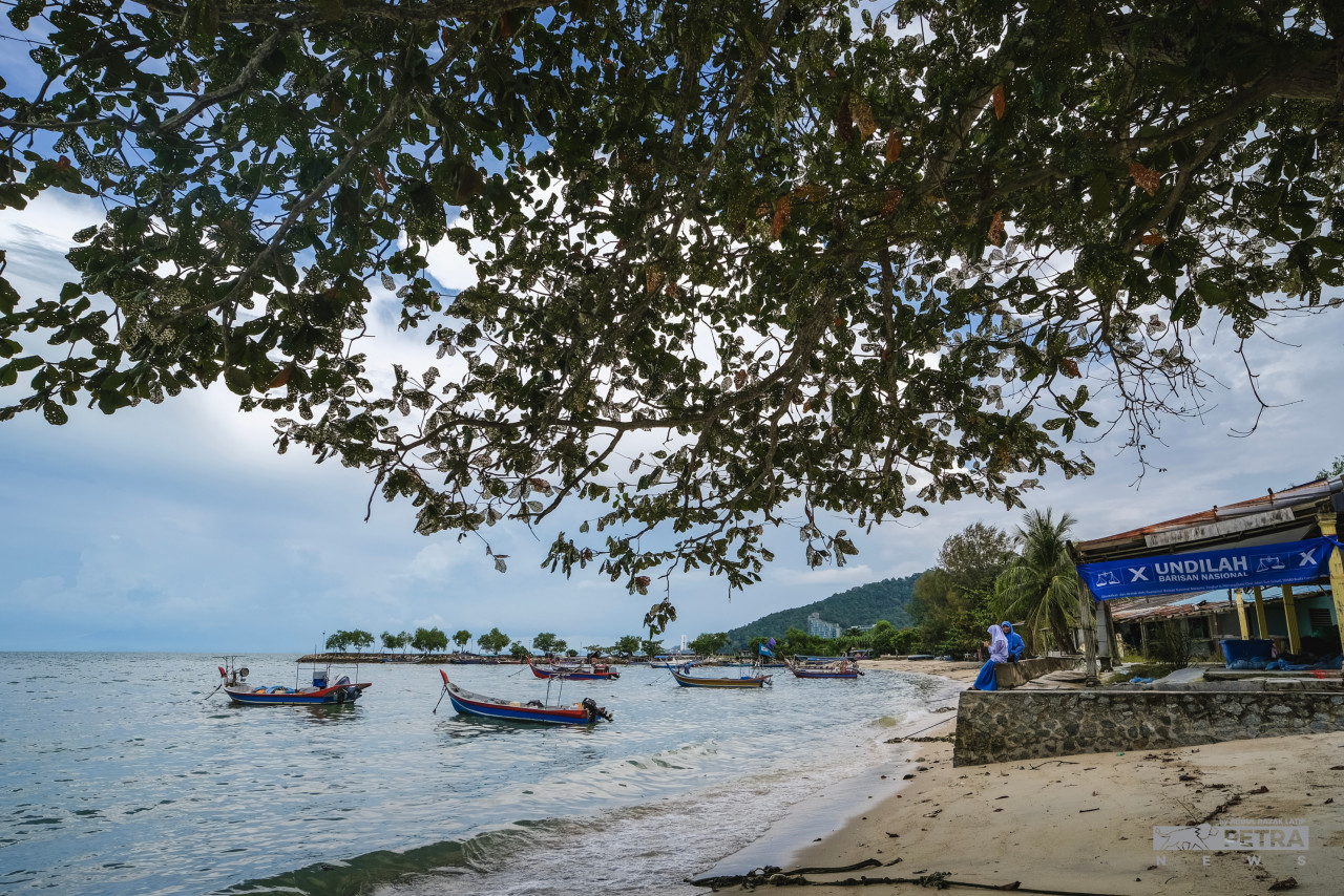 A Barisan Nasional banner hangs by the beach at Teluk Bahang in George Town, Penang, while a fishing boat in the distance is seen flying the Perikatan Nasional flag. The campaigning period for the general election has seen the now-familiar flag wars gather pace. – ABDUL RAZAK LATIF/The Vibes pic, November 10, 2022