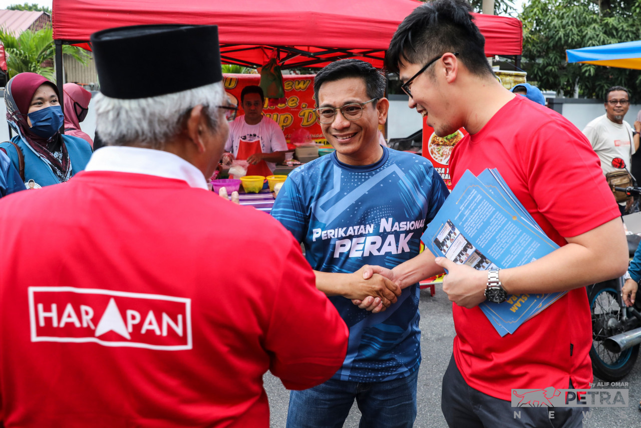 Pakatan Harapan’s (PH) candidate for the Tebing Tinggi state seat, Prof Abdul Aziz Bari (left) and PH’s candidate for the Ipoh Timur parliamentary seat, Howard Lee (right), shake hands with Perikatan Nasional’s candidate for Tebing Tinggi, Muhammad Iskandar Abdul Rahman, during a walkabout at the night market in Desa Aman, Ipoh, today. – ALIF OMAR/The Vibes pic, November 14, 2022