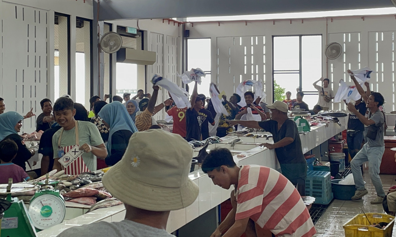 Fishmongers and workers in Semporna fish market excitedly cheer for Warisan when members came to distribute party flags, flyers, and stickers. – REBECCA CHONG/The Vibes pic, November 17, 2022 
