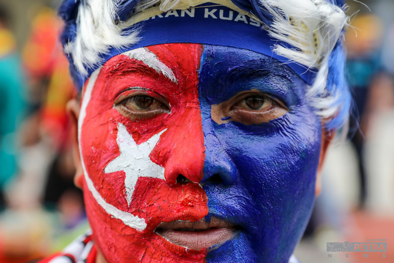A Johor Darul Ta’zim FC fan has his entire face painted in the colours of the state flag at Bukit Jalil National Stadium, Kuala Lumpur for tonight’s Malaysia Cup final. – ALIF OMAR/The Vibes pic, November 26, 2022