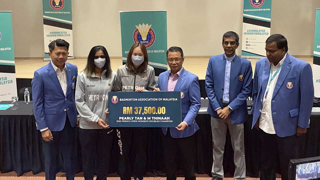 National badminton players M. Thinaah (second left) and Pearly Tan (third left) pose with a mock cheque presented by Badminton Association of Malaysia president Tan Sri Mohamad Norza Zakaria (third right) for the pair’s win in this year’s French Open. – SAKTESH SUBRAMANIAM/The Vibes pic, November 26, 2022