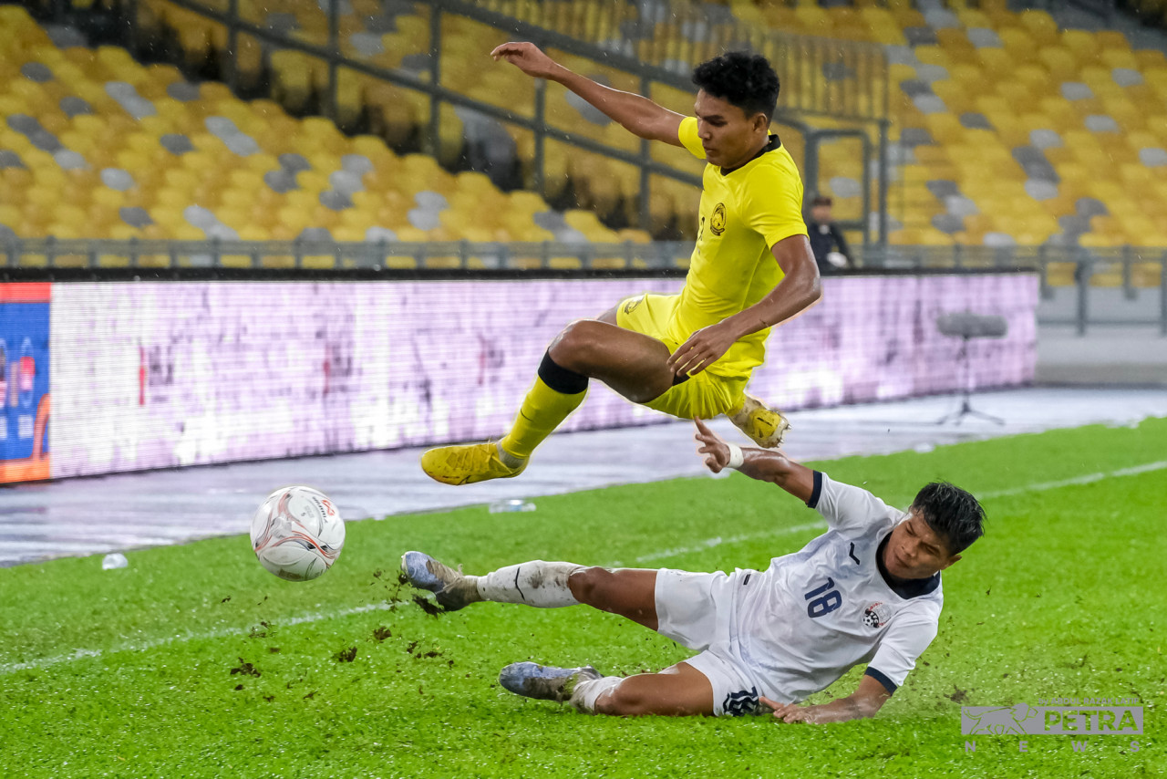 Harimau Malaya’s Muhammad Azam Azmi Murad (left) rides a challenge from Cambodia’s Seut Baraing in their friendly clash at Bukit Jalil National Stadium last night. – ABDUL RAZAK LATIF/The Vibes pic, December 10, 2022