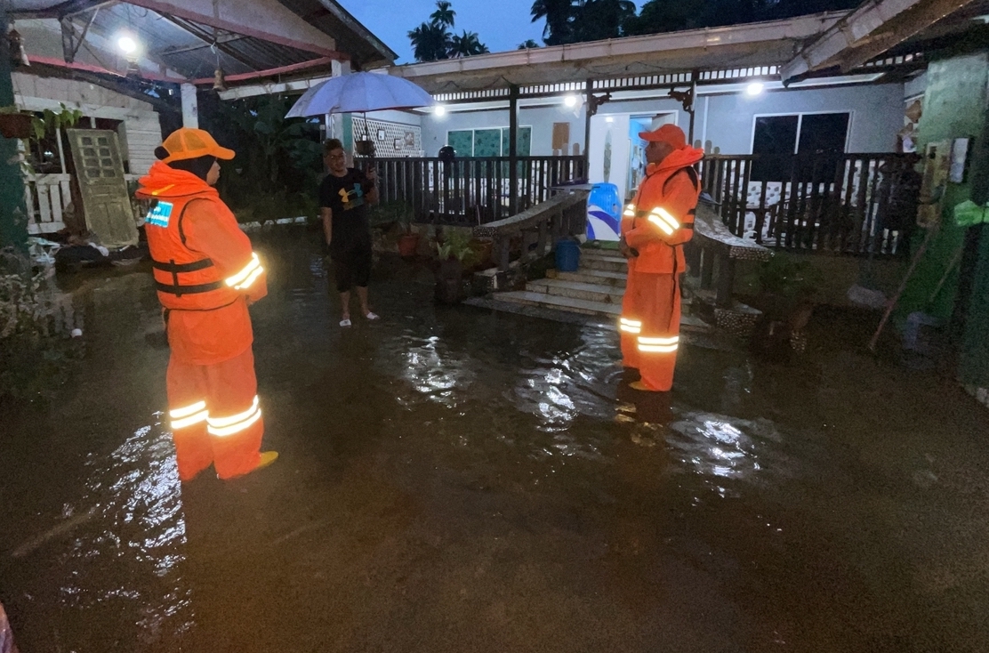 Civil Defence Force personnel speak to a flood victim in Kg Bedaun this morning. – Civil Defence Force pic, December 23, 2022