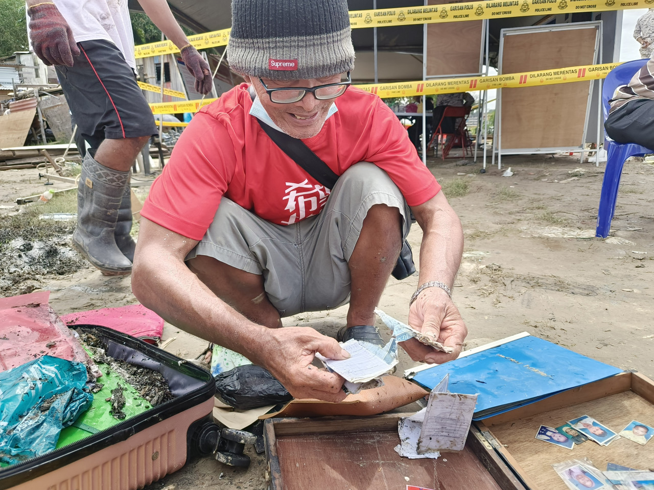 Muslimin Basanun, 70, finds pictures of his children and grandchildren, and certificates from his son’s school days. – REBECCA CHONG/The Vibes pic, December 26, 2022