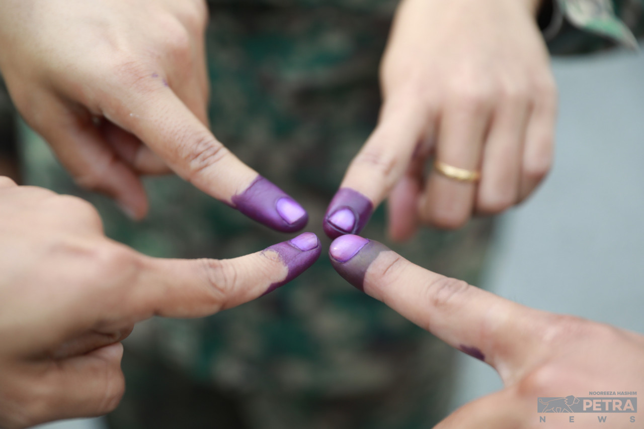 Military personnel show off their indelible ink-stained index fingers after early voting today in Batu Caves. – NOOREEZA HASHIM/The Vibes pic, August 8, 2023
