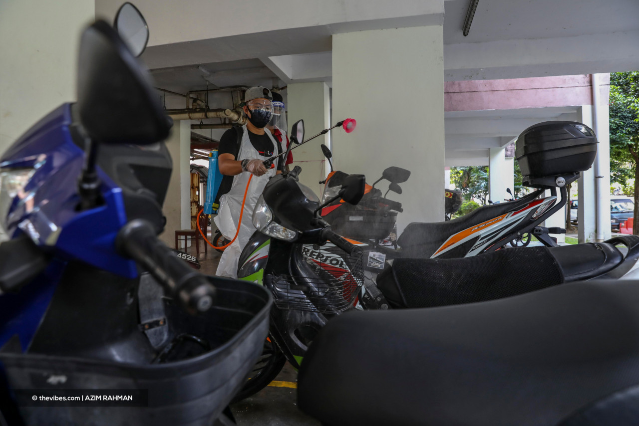 A Block B committee member sanitises motorcycles. The group carries out Covid-19 fogging at the building two to three times a week. – AZIM RAHMAN/The Vibes pic, August 15, 2021