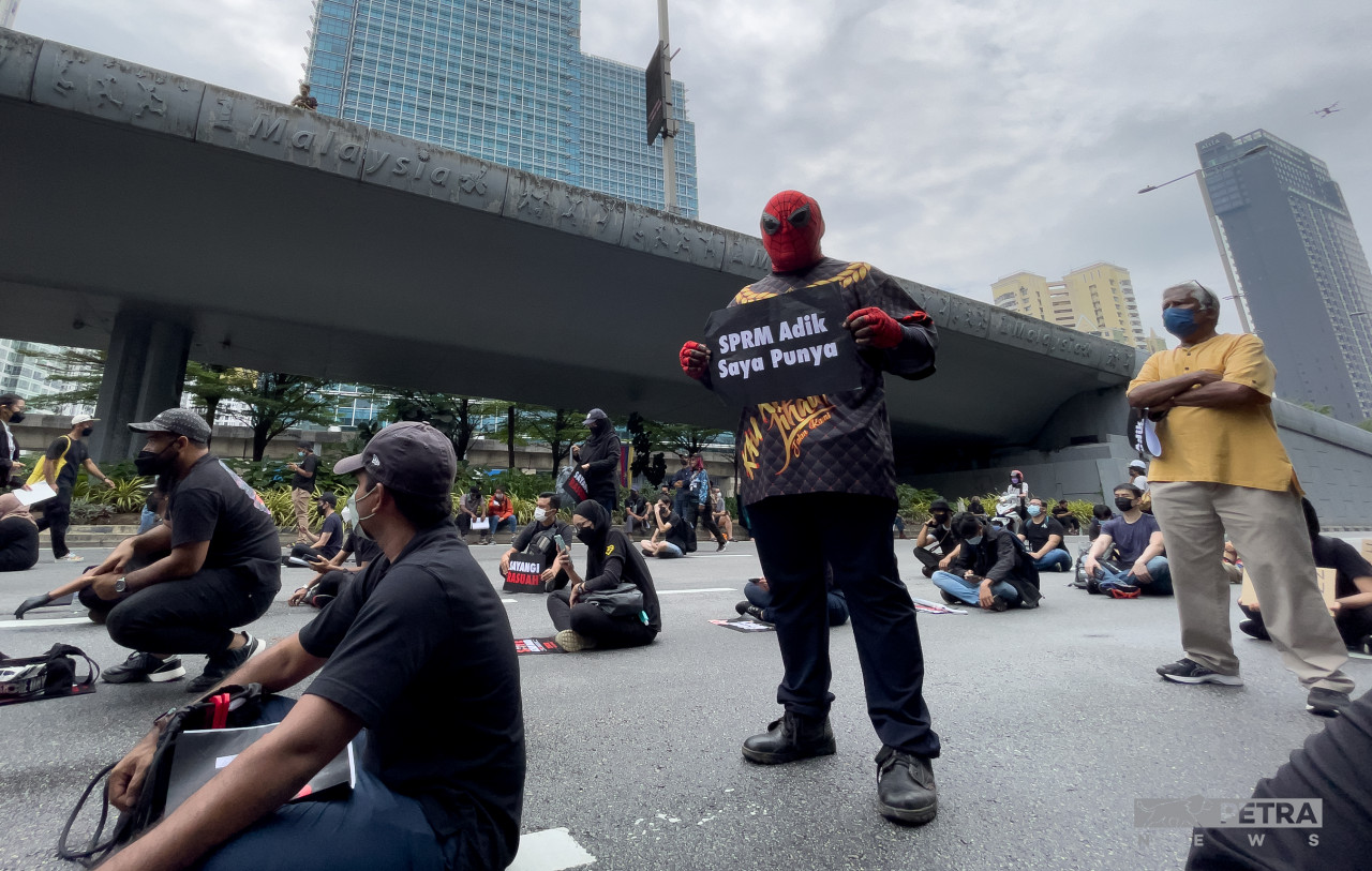 A protester dressed in Spiderman costume carrying a sign saying: "MACC is my brother's." – EMMANUEL SANTA MARIA CHIN/The Vibes pic, January 22, 2022