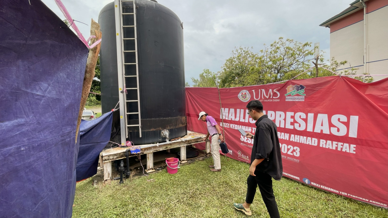 Officers from the Sepanggar Parliamentary Office inspect the common tank where the treated water supply is sent and stored inside for students at Universiti Malaysia Sabah residential colleges. Although treated water supply is being sent in by lorries to a common water tank, students say that this source of supply is not enough and that it only lasts for about an hour or two. – JASON SANTOS/The Vibes pic, January 26, 2023 