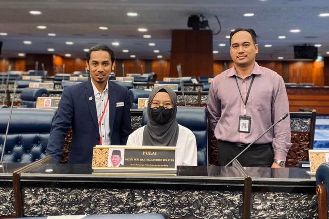 Fatihah Salahuddin (centre) wears her father’s white shirt as she retrieves his nameplate from the Parliament today. – Fatihah Salahuddin Facebook pic, August 9, 2023