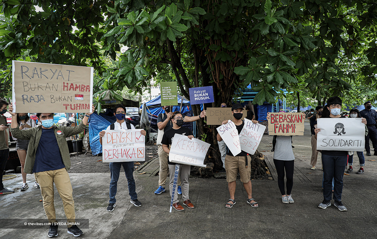 Fahmi Reza supporters holding signs outside the Dang Wangi police headquarters this morning. – SYEDA IMRAN/The Vibes pic, April 24, 2021