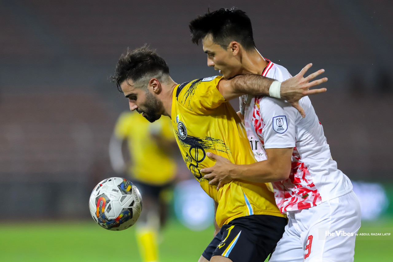 Penang FC player Hassan Saad (left) being tackled by KL City player Sebastian Osbol Avanzini. – ABDUL RAZAK LATIF/The Vibes pic, February 26, 2023