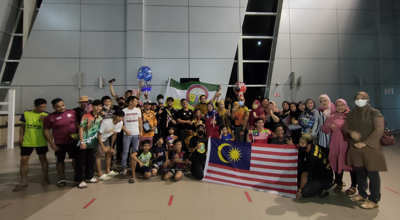 Dazaisy Hafie Aznee and his brother Dazrey Dinnie Aznee are welcomed by  friends, family, and fellow Muay Thai fighters at the airport last Tuesday as they came back from the IFMA World Youth Muay Thai Championship in Selangor. – REBECCA CHONG/The Vibes pic, August 28, 2022