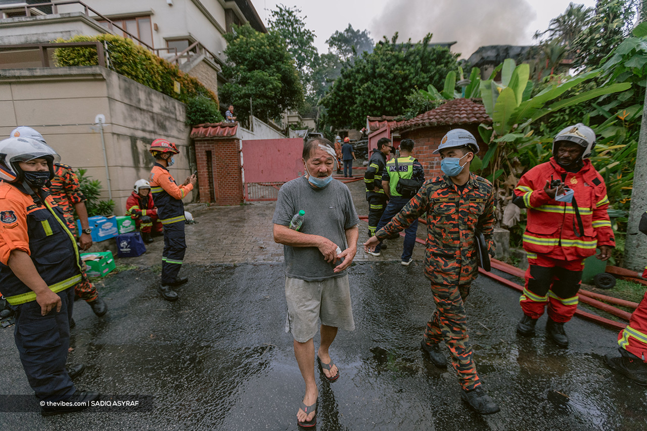 An injured man walking away from the house as the blaze was being put out in Taman Duta today. – SADIQ ASYRAF/The Vibes pic, April 26, 2021