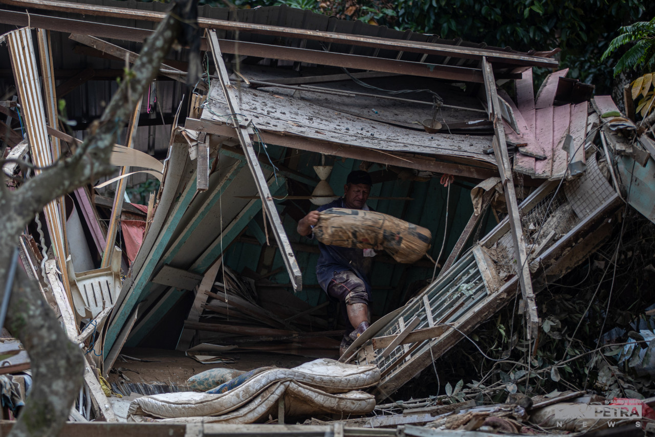 Resident Haslan Abdul Aziz trying to salvage items from his flood-hit home in Hulu Langat. – SAIRIEN NAFIS/The Vibes pic, December 30, 2021