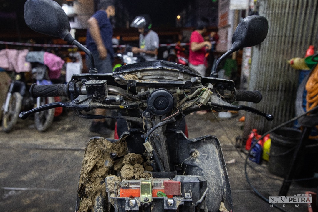 A mud-covered motorcycle left standing forlornly after the floods swept through an auto workshop in Hulu Langat. – SAIRIEN NAFIS/The Vibes pic, December 30, 2021