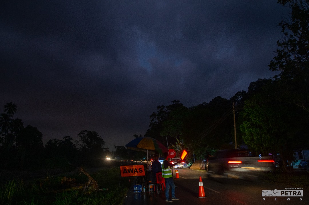 Volunteers take turns to man traffic in Hulu Langat after parts of the access road were damaged by the floods. – SAIRIEN NAFIS/The Vibes pic, December 30, 2021